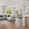 Spacious well lit living room adjacent to the kitchen with large windows.
