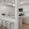 Spacious well lit kitchen adjacent to large windows with stainless steel appliances.