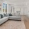 Spacious naturally lit living room with large windows and wood floors.