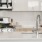 Spacious well lit kitchen with stainless steel appliances.