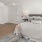 Spacious well lit bedroom with wood floors and a large windows