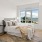 Spacious and well lit bedroom with plush carpet and large windows