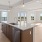 Spacious and well lit kitchen with wood floors and stainless steel appliances. 