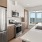 Spacious and well lit kitchen with wood floors and stainless steel appliances. 