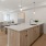 Spacious and well lit kitchen with wood floors and stainless steel appliances. 